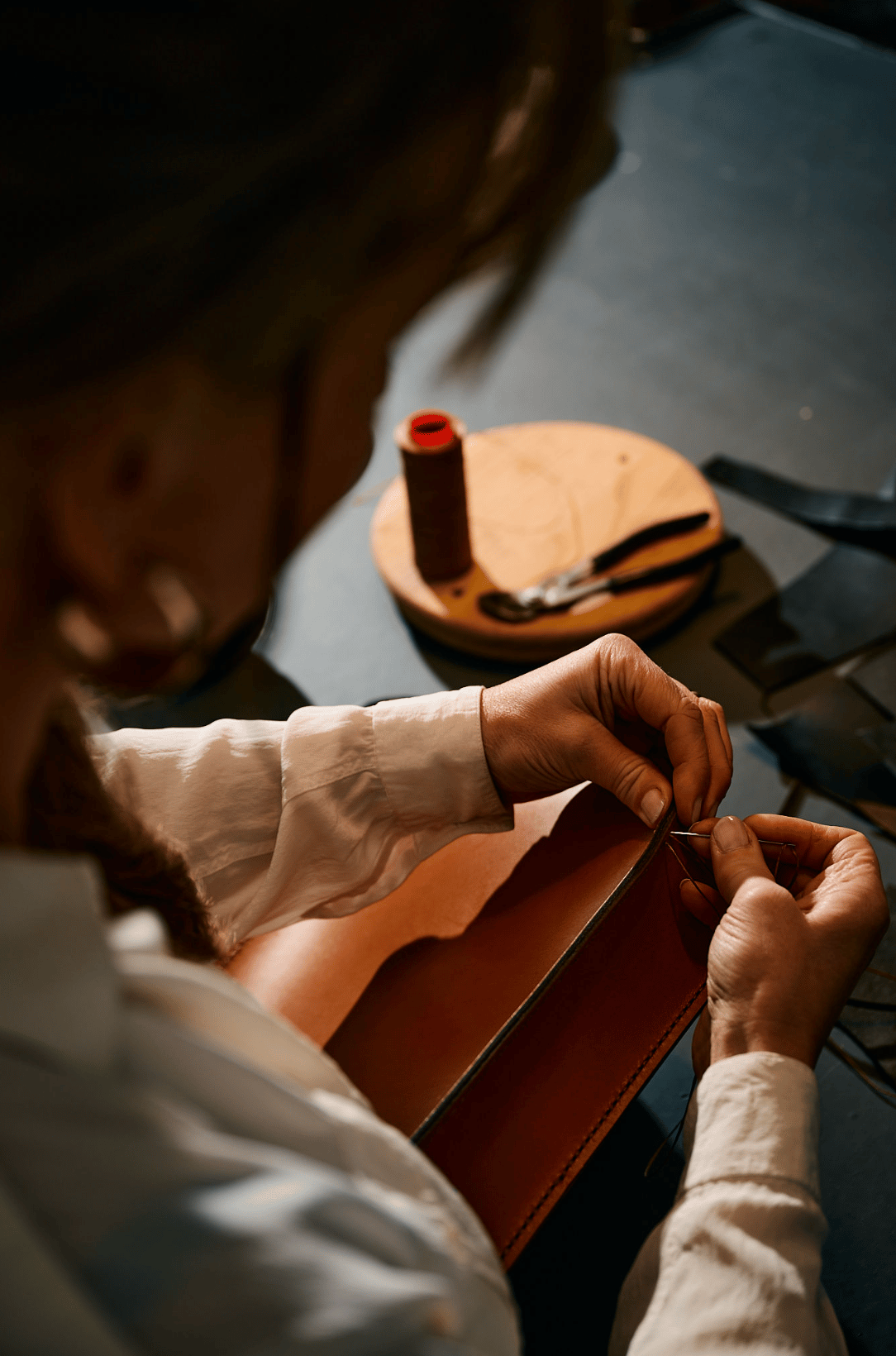 LINFIN hand-stitched leather bag resting on pure European linen