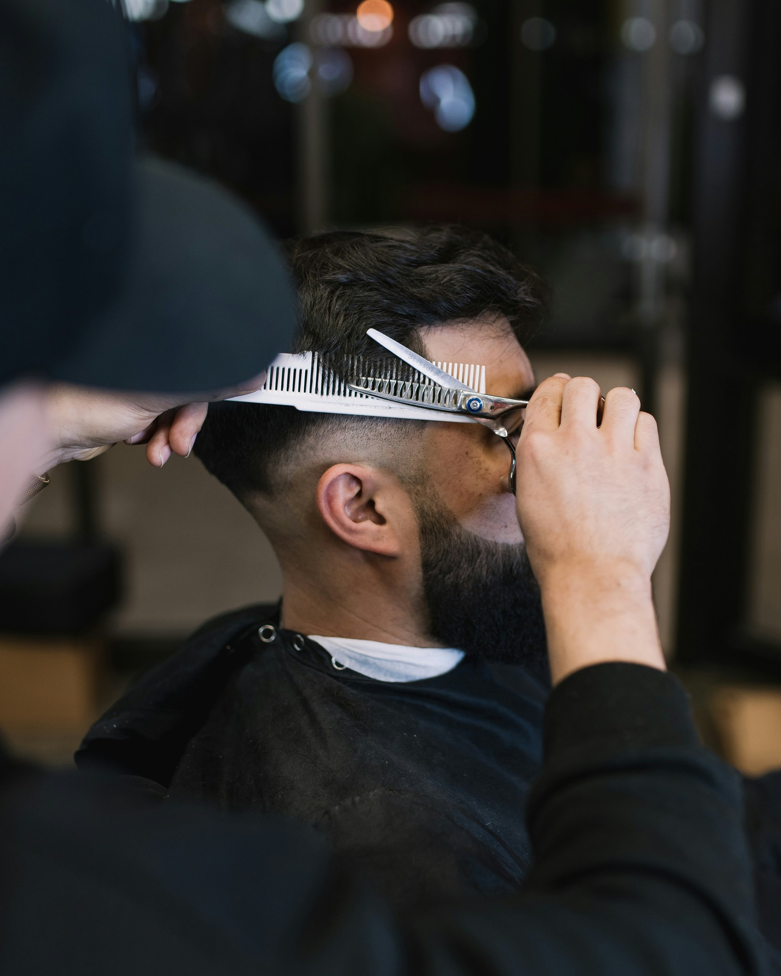 Scissor-over-comb cut on a bearded client in the chair
