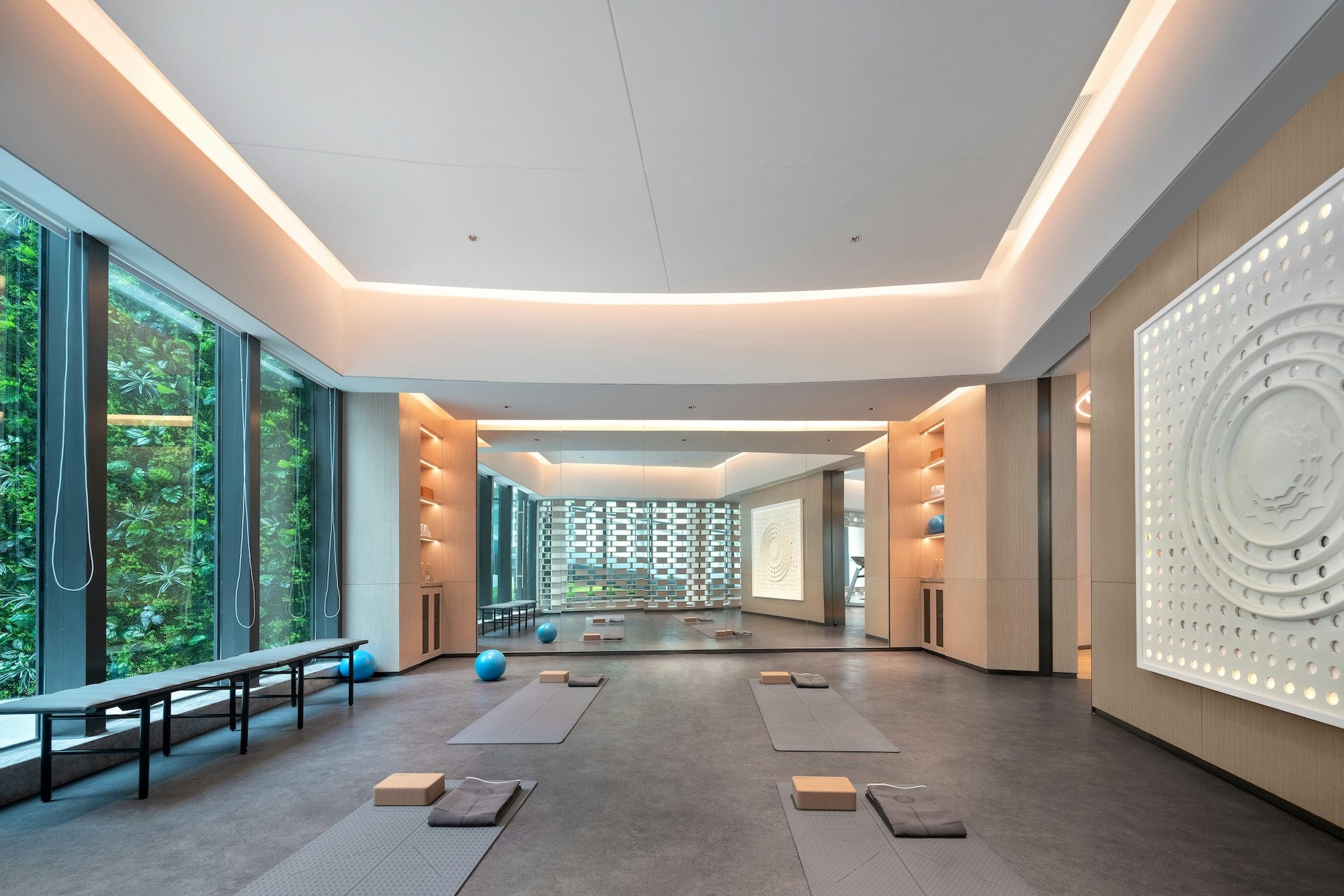 The practice room at Maison Verte, with mats laid out along a green living wall