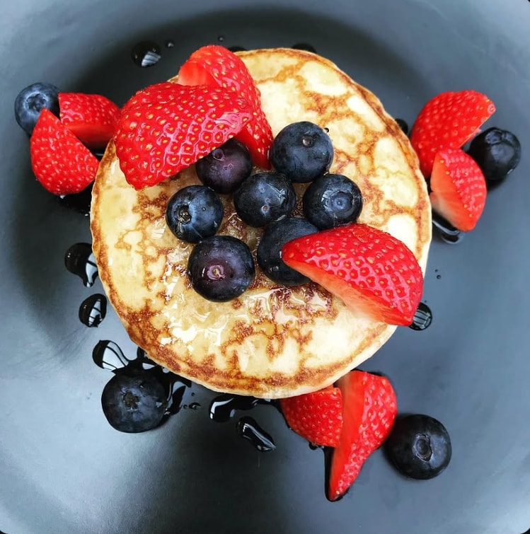 Dikke American pancake met verse aardbeien en bosbessen