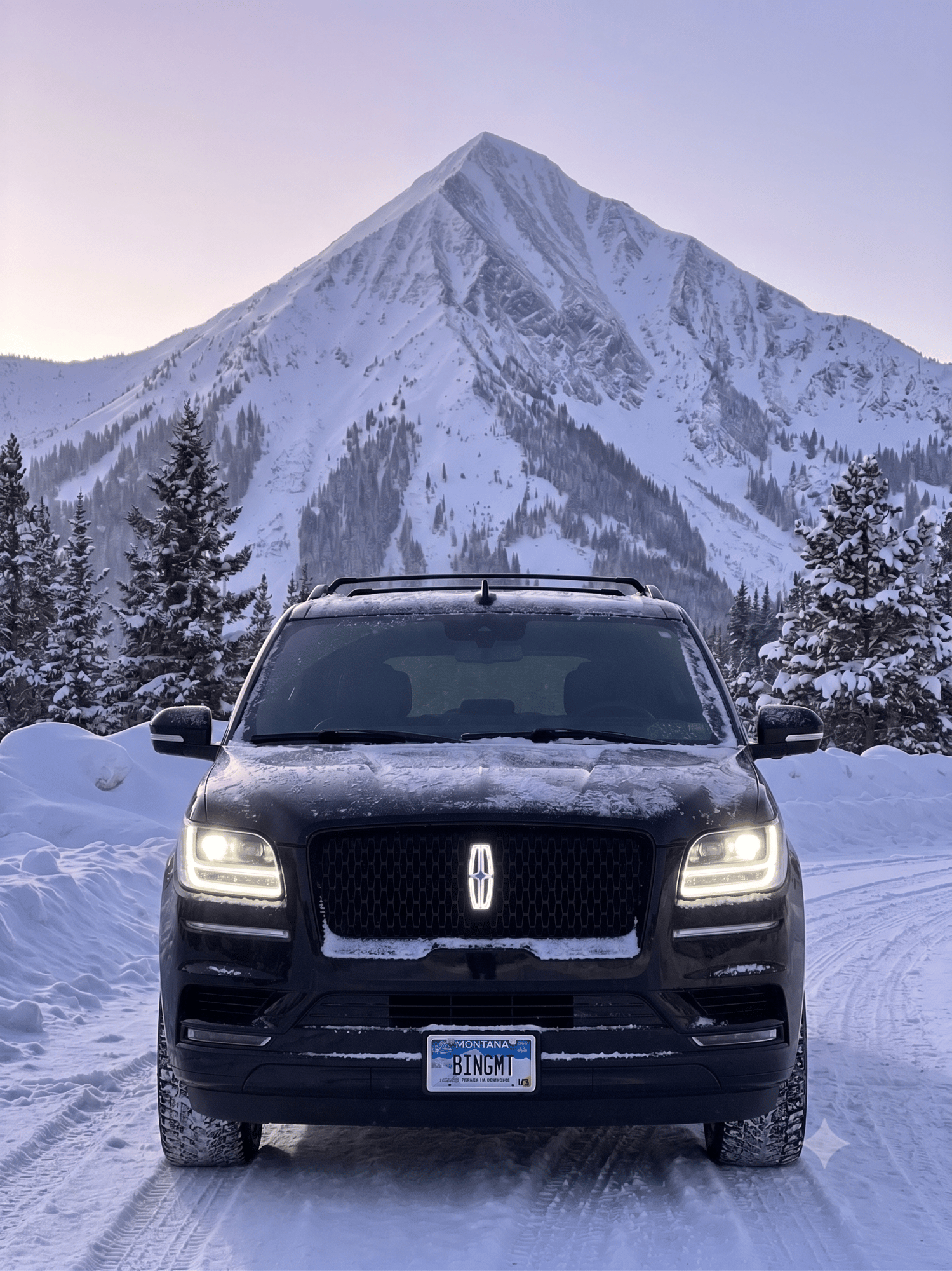 Bing Mountain Lincoln Navigator with BINGMT Montana plates on a snowy mountain road — Luxury Transportation, Big Sky MT