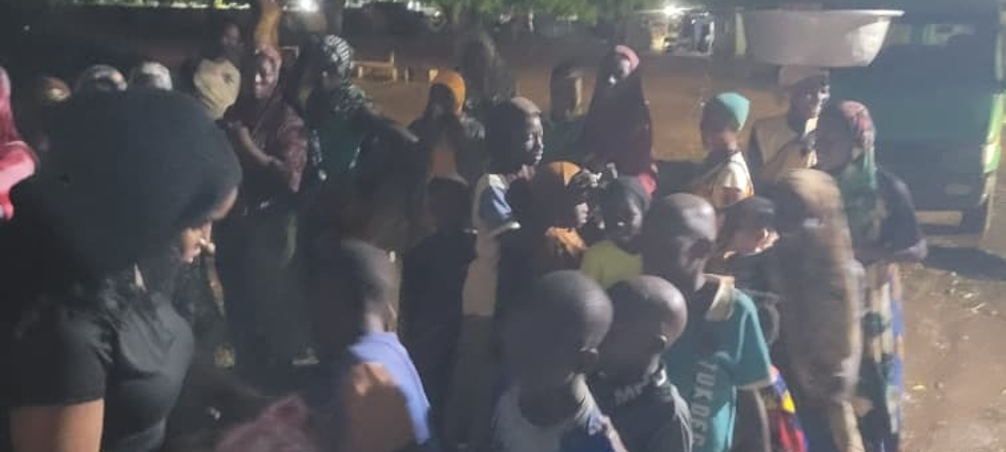 TWHM volunteers handing out meals to children and families at night