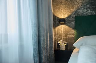 Doppelbett mit grüner Wand im Zimmer mit Balkon