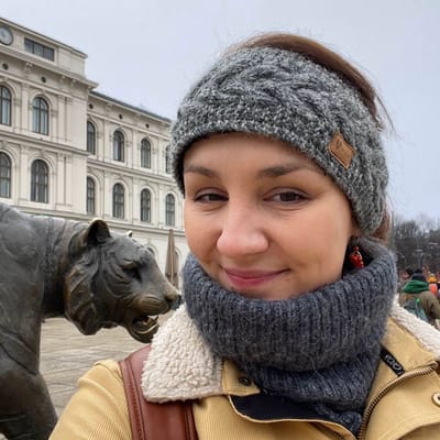 Katerina, founder of OsloWay, smiling in front of the Royal Palace in Oslo
