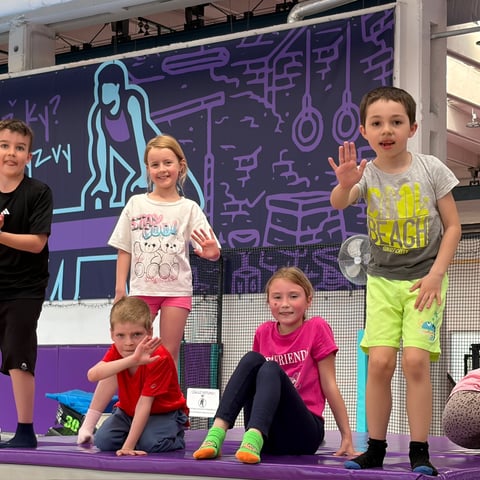 Skupina dětí mává na trampolíně – školní výlet UMPARK