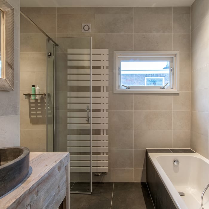Badkamer laten renoveren Haaglanden — strakke afwerking wand en vloertegels