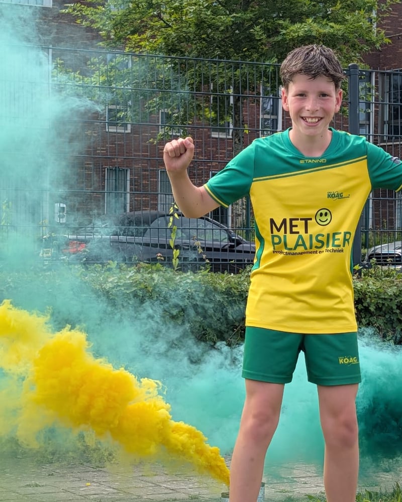 CKV KOAG speler in tenue met Met Plaisier sponsor en rookbommen