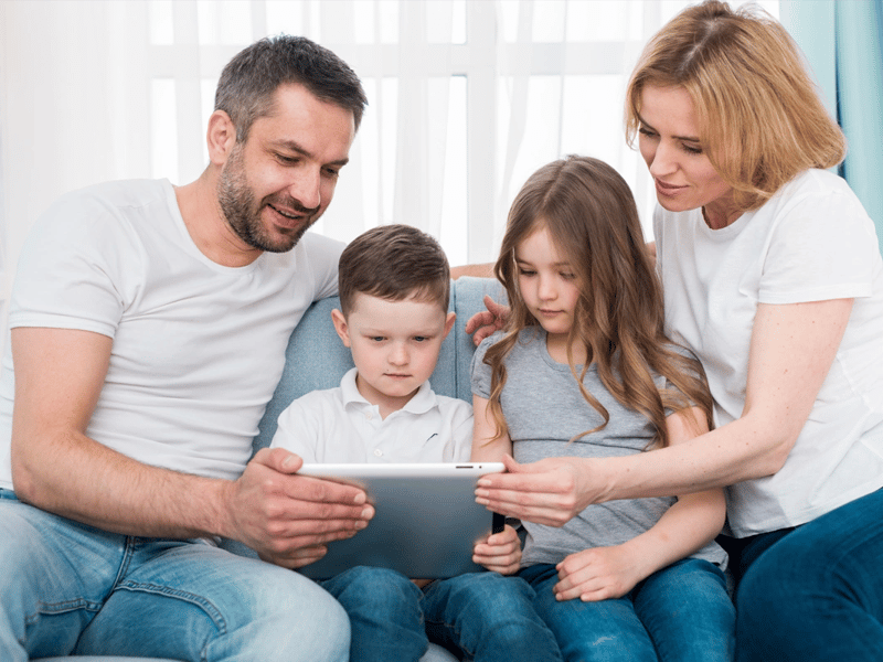 Familia navegando con una tableta delante de una pantalla
