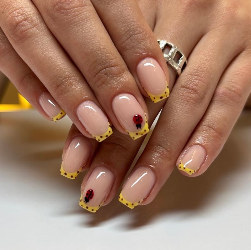 Yellow French tips with ladybug nail art