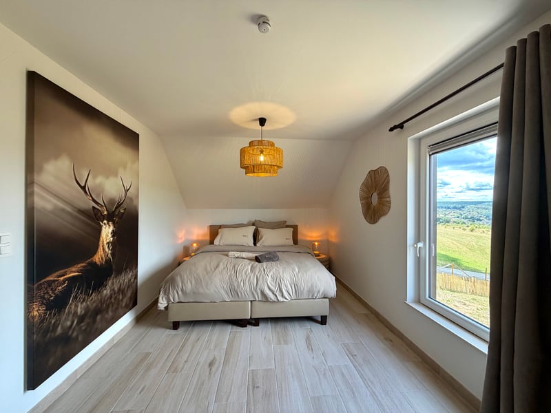 Slaapkamer met boxspring en hertschilderij