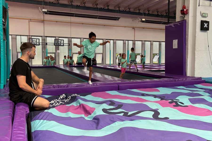 Instruktor sleduje děti při skákání na trampolíně – tábor UMPARK