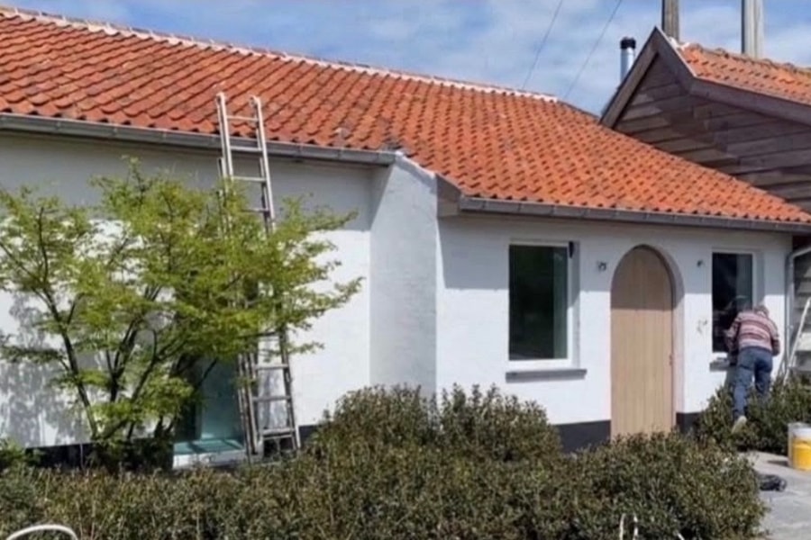 Vakman kaleiert gevel van villa in Gistel