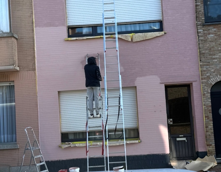 Vakman kaleiert gevel op ladder — werf Blankenberge