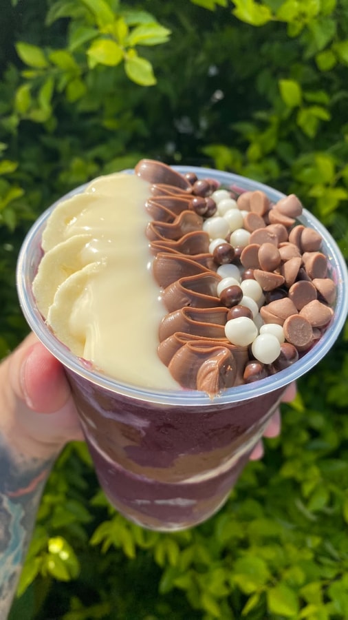 Copo de açaí com banana, leite condensado, creme de avelã e gotas de chocolate