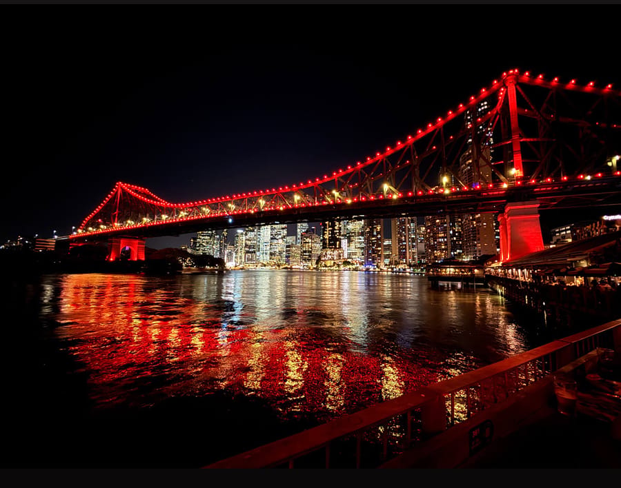 Story Bridge lit up red over the Brisbane River at night