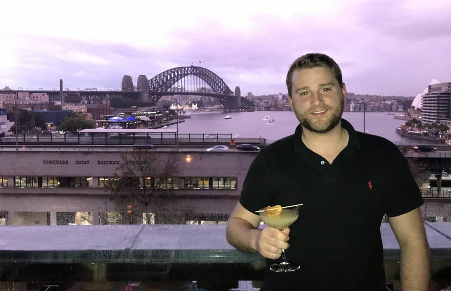 Darren enjoying a drink with the Sydney Harbour Bridge behind him