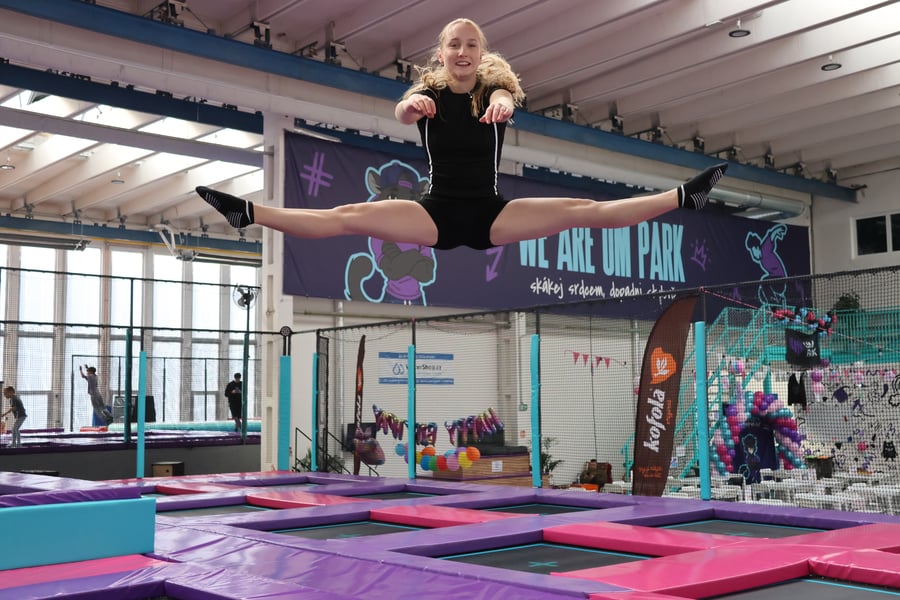 Dívka skáče na trampolíně UMPARK Ostrava a dělá špagát ve vzduchu – WE ARE UM PARK banner