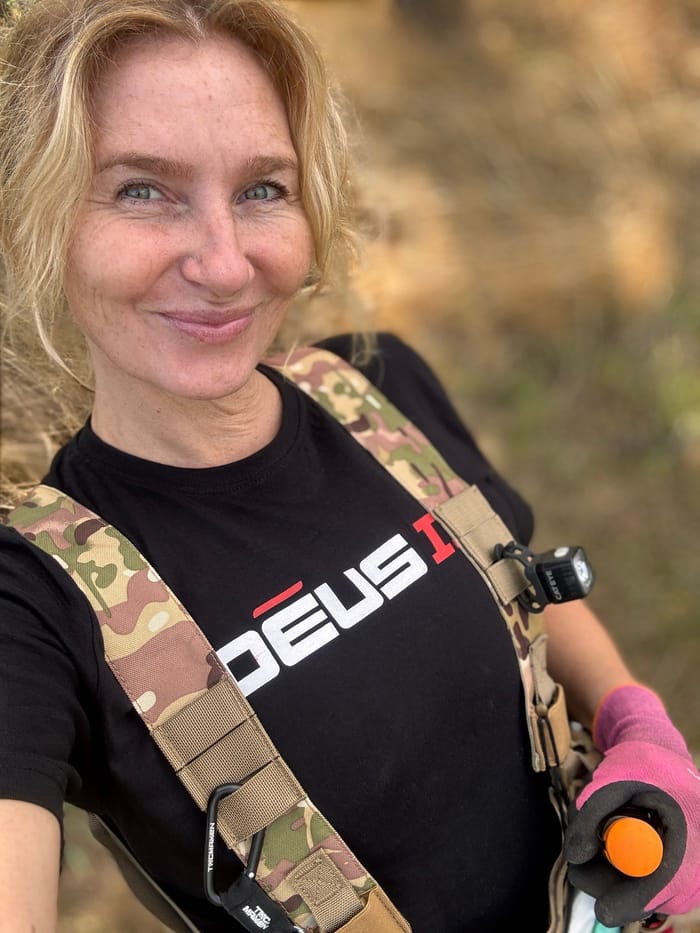 Detector Lady in the field, harness on and detector in hand