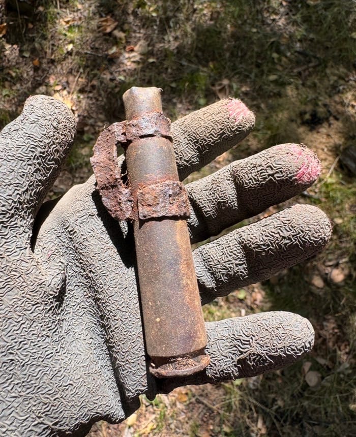 An American 50 BMG cartridge resting in a gloved hand