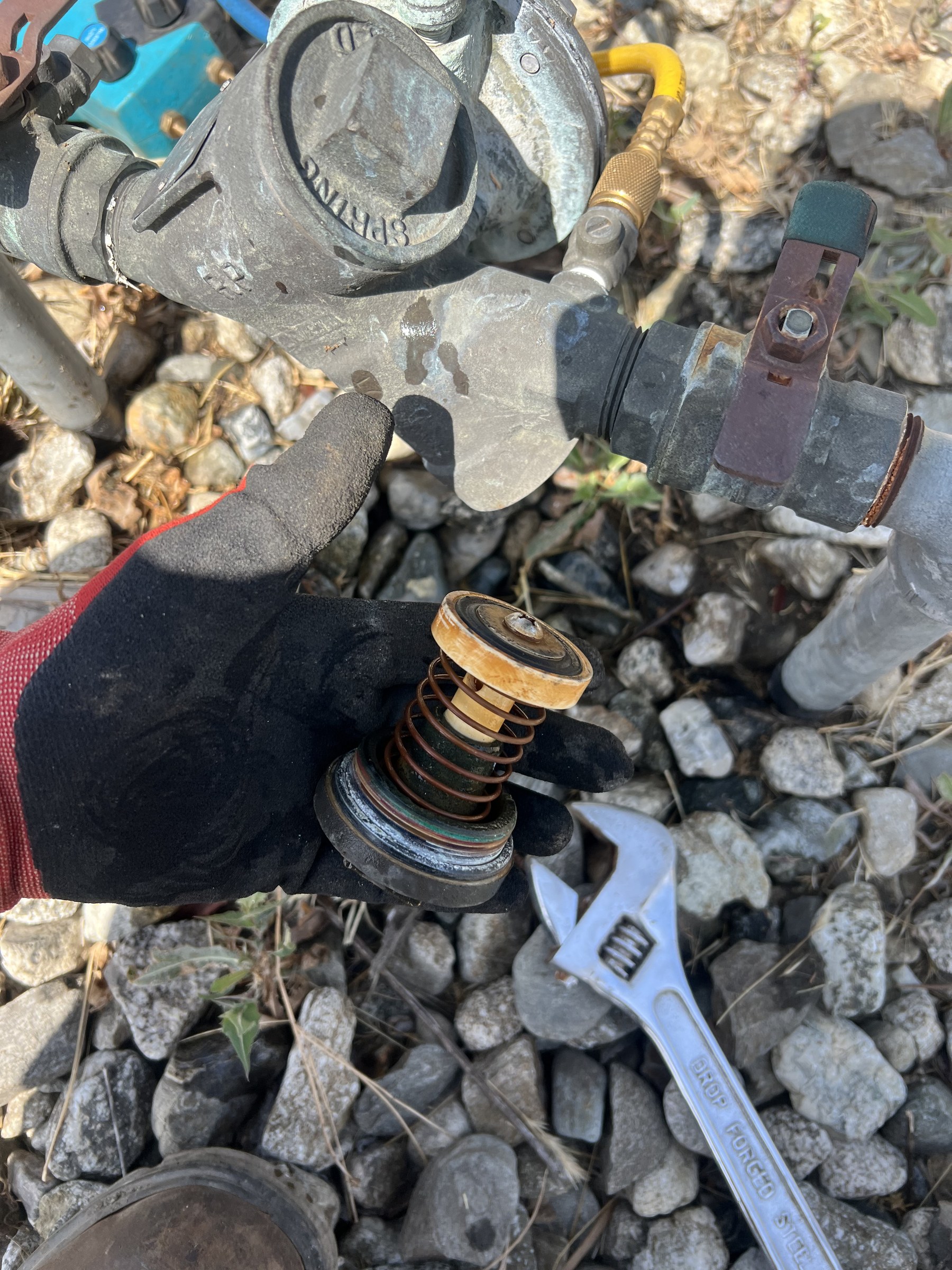 Gloved hands rebuilding a backflow check valve during an on-site repair in Orange County CA