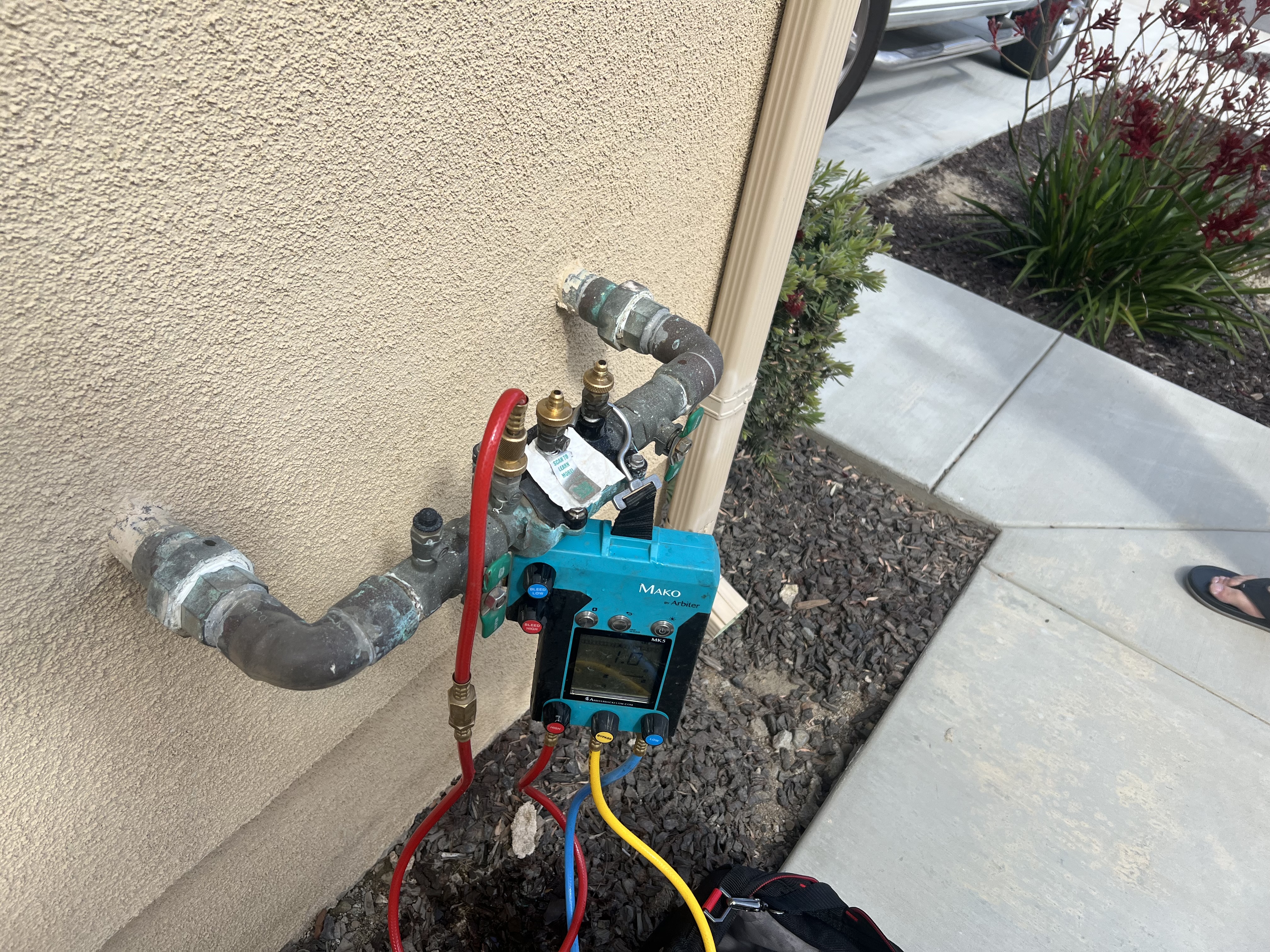 Technician using a Mako backflow test kit on a residential backflow preventer in Riverside, CA