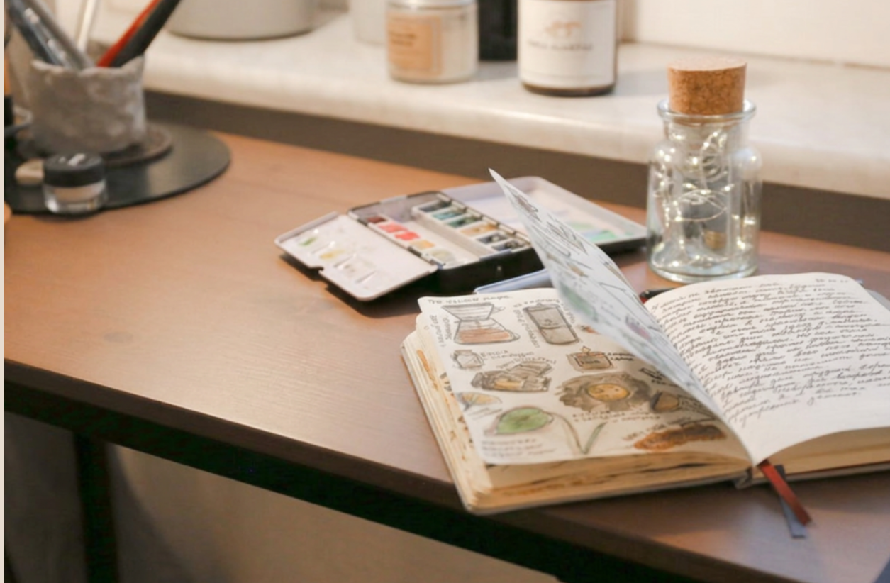 Open sketchbook with warm artistic supplies