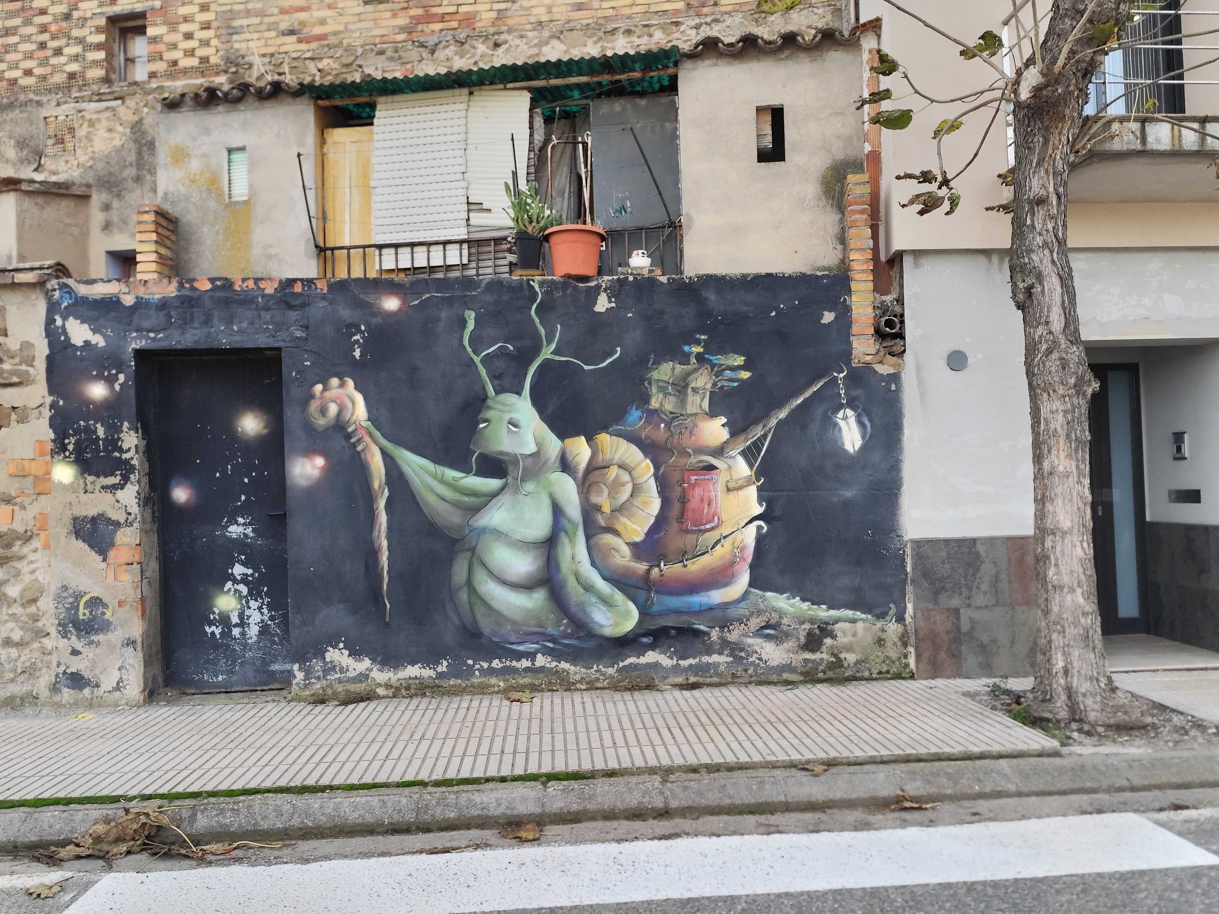 Esténcil Hi ha vida abans de la mort? sobre un muro encalado, Penelles