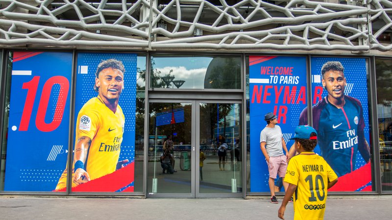 Paris, France - August 20, 2017: Doors of PSG Store with Poster of Neymar and little boy in his football player t-shirt in Paris, France on August 20, 2017