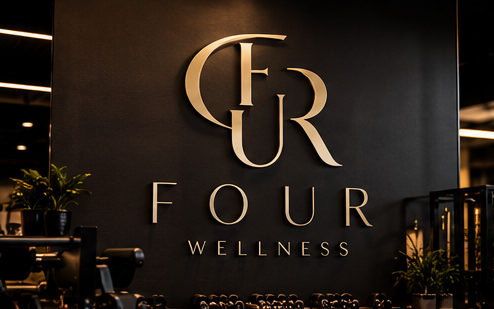 Insegna FOUR WELLNESS in lettere oro su parete scura della palestra