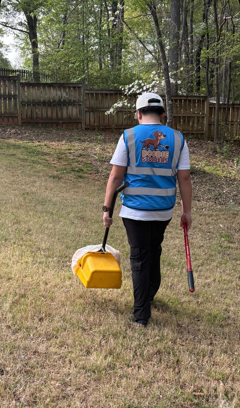 Technician walking from a fenced backyard carrying gear