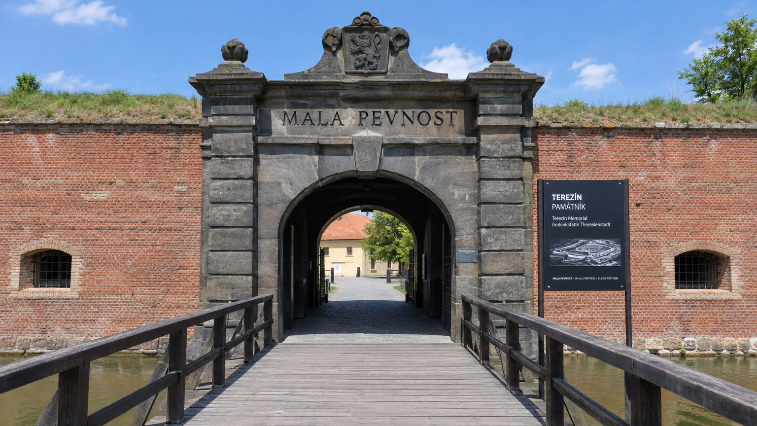 Entrada con la inscripción Mala Pevnost y el cartel del Memorial de Terezín