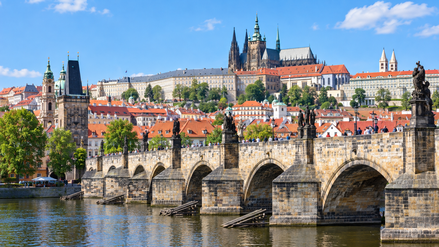 Puente de Carlos sobre el río Vltava con el Castillo de Praga al fondo en un día soleado