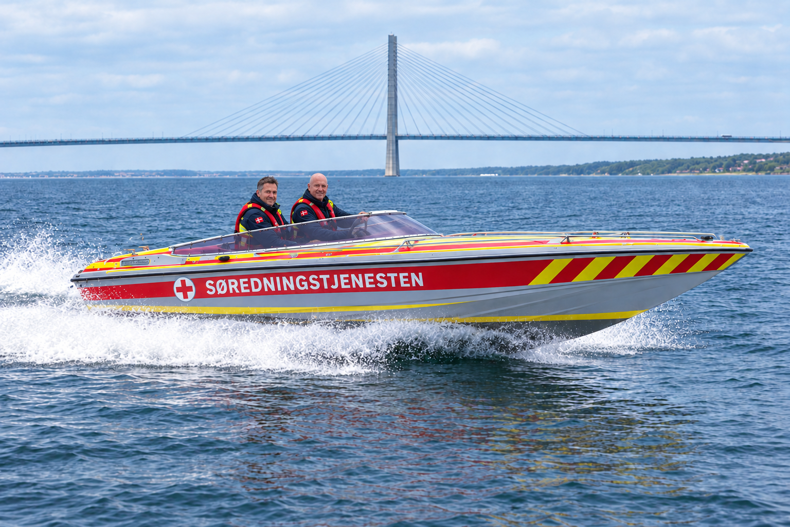 Speedbåden Sea Star 23 i fart foran broen, med to frivillige i redningsveste om bord