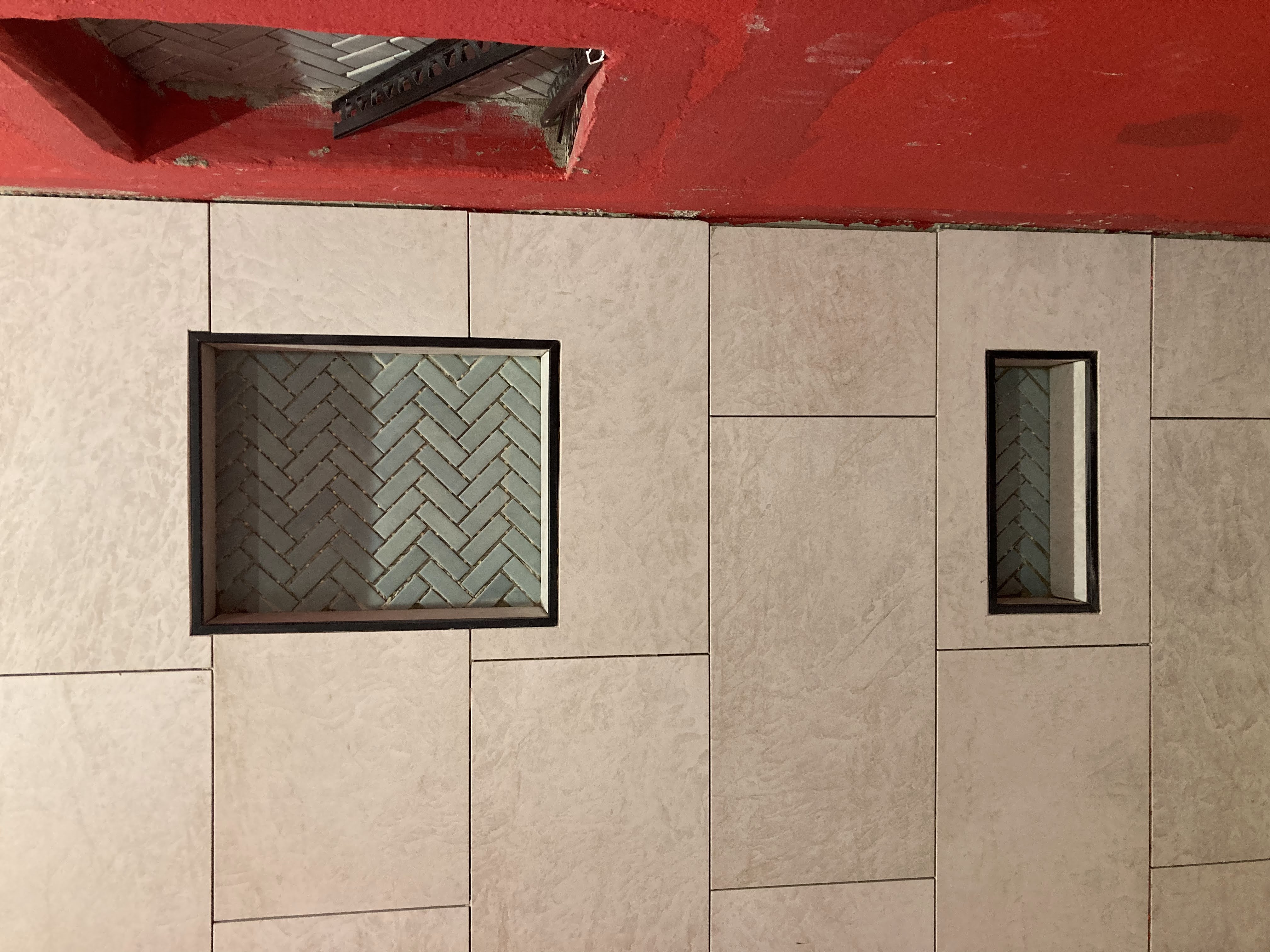 Bathroom tile work — large format tile with herringbone niche accents