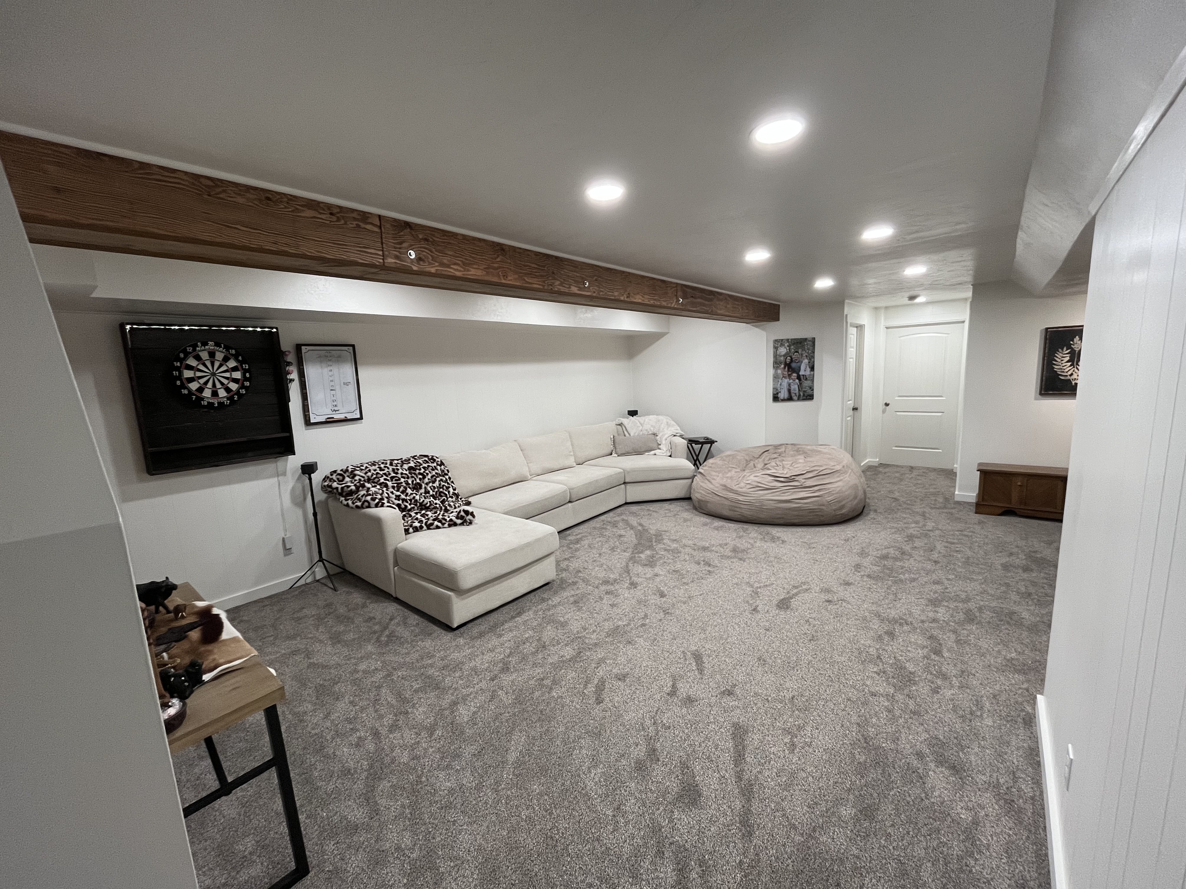 Finished basement rec room — carpet, recessed lighting, wood beam