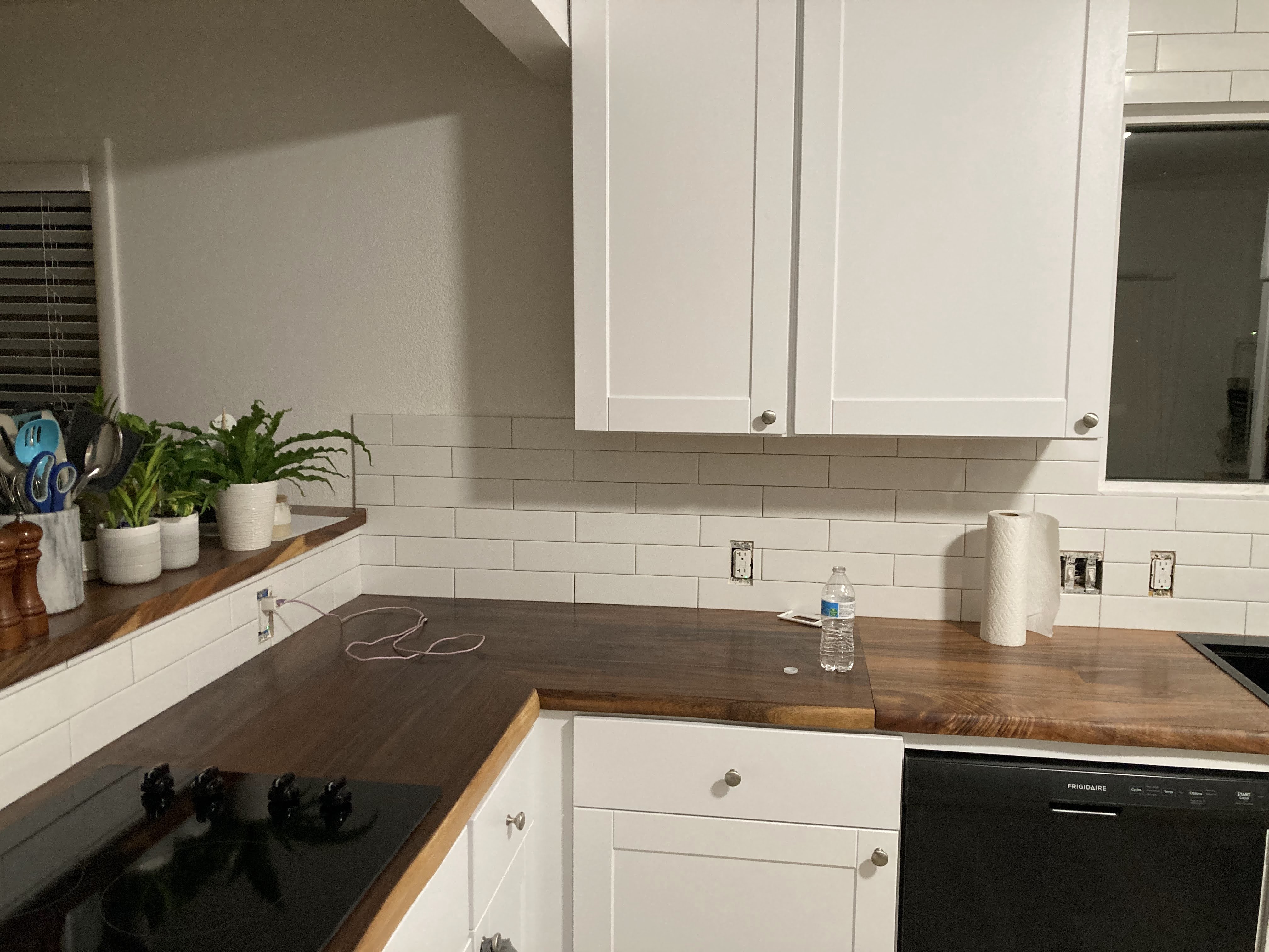 Completed kitchen remodel — white shaker cabinets, butcher block counters, subway tile backsplash
