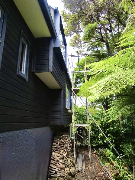 Hillside home with badly weathered cedar cladding before work began