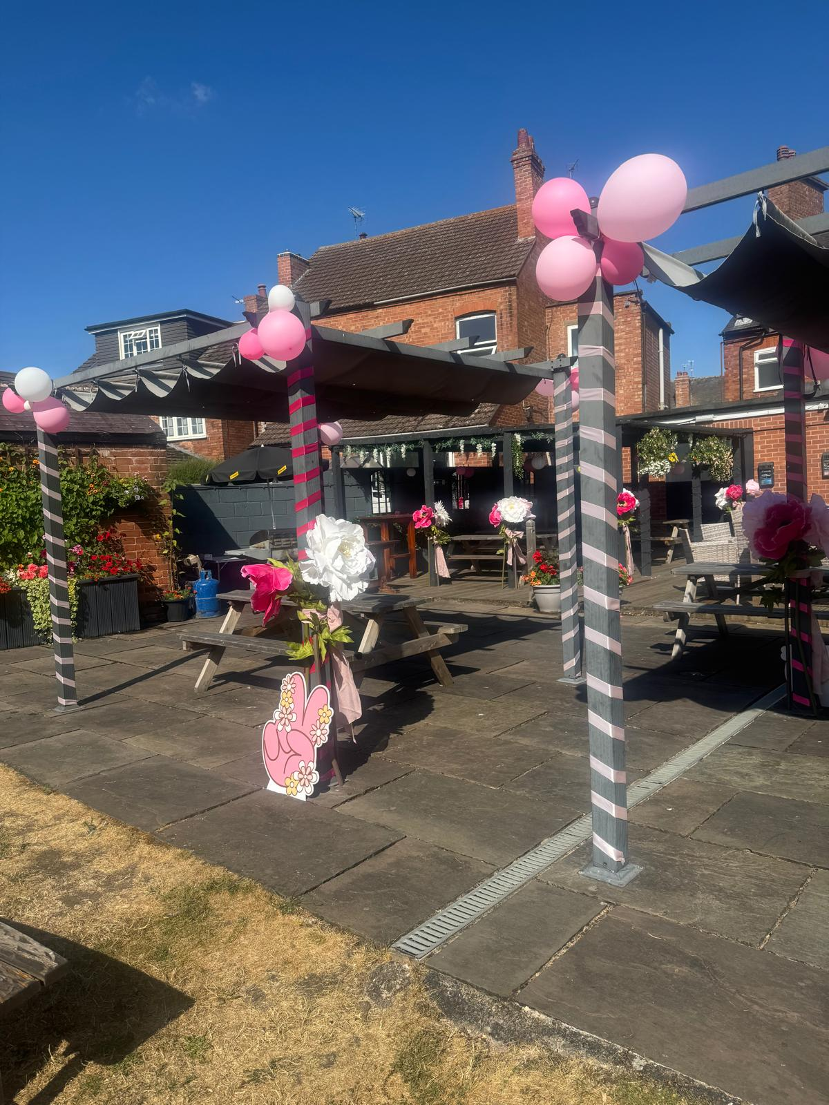The covered garden seating dressed with balloons and flowers for a party