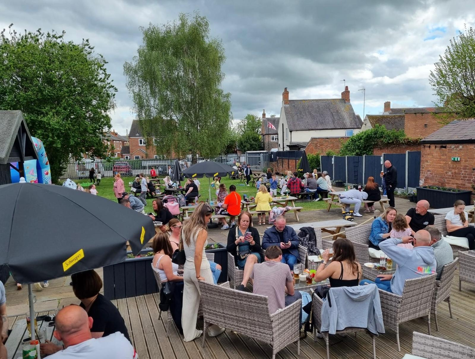 A busy afternoon in the beer garden with picnic benches and guests