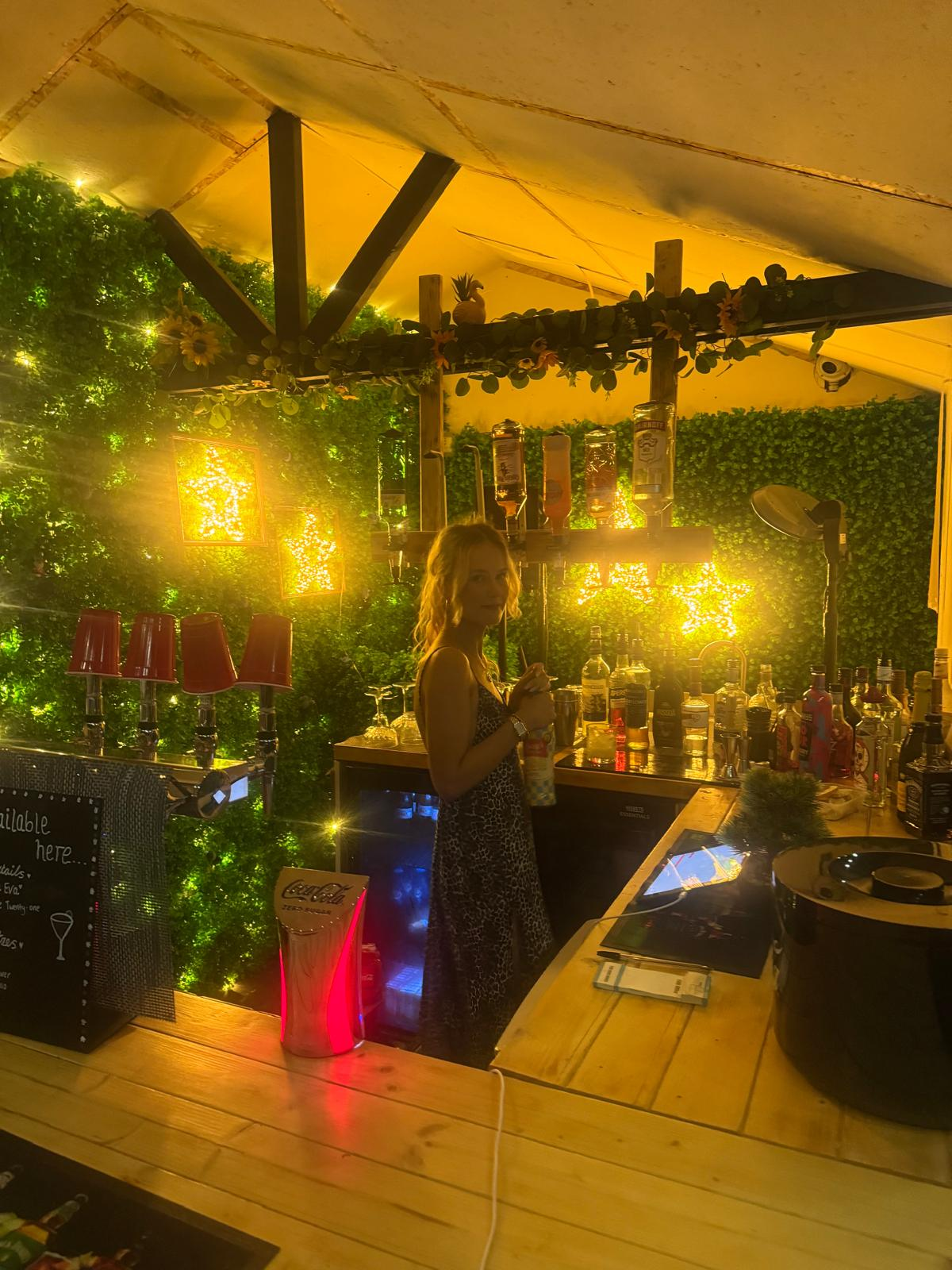 The outdoor bar lit up under the marquee, with a barman ready to serve