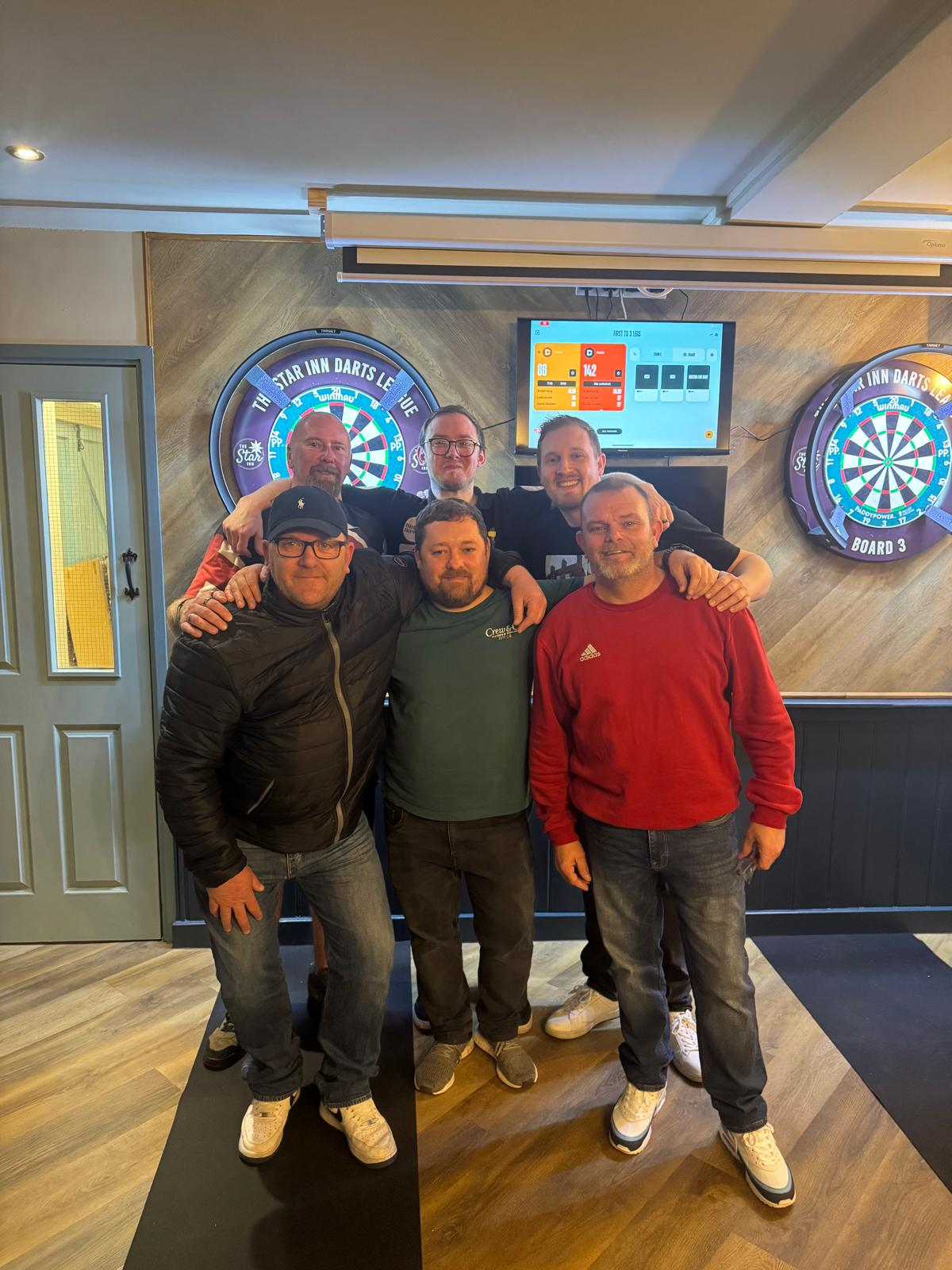 The darts team posing by the boards on league night