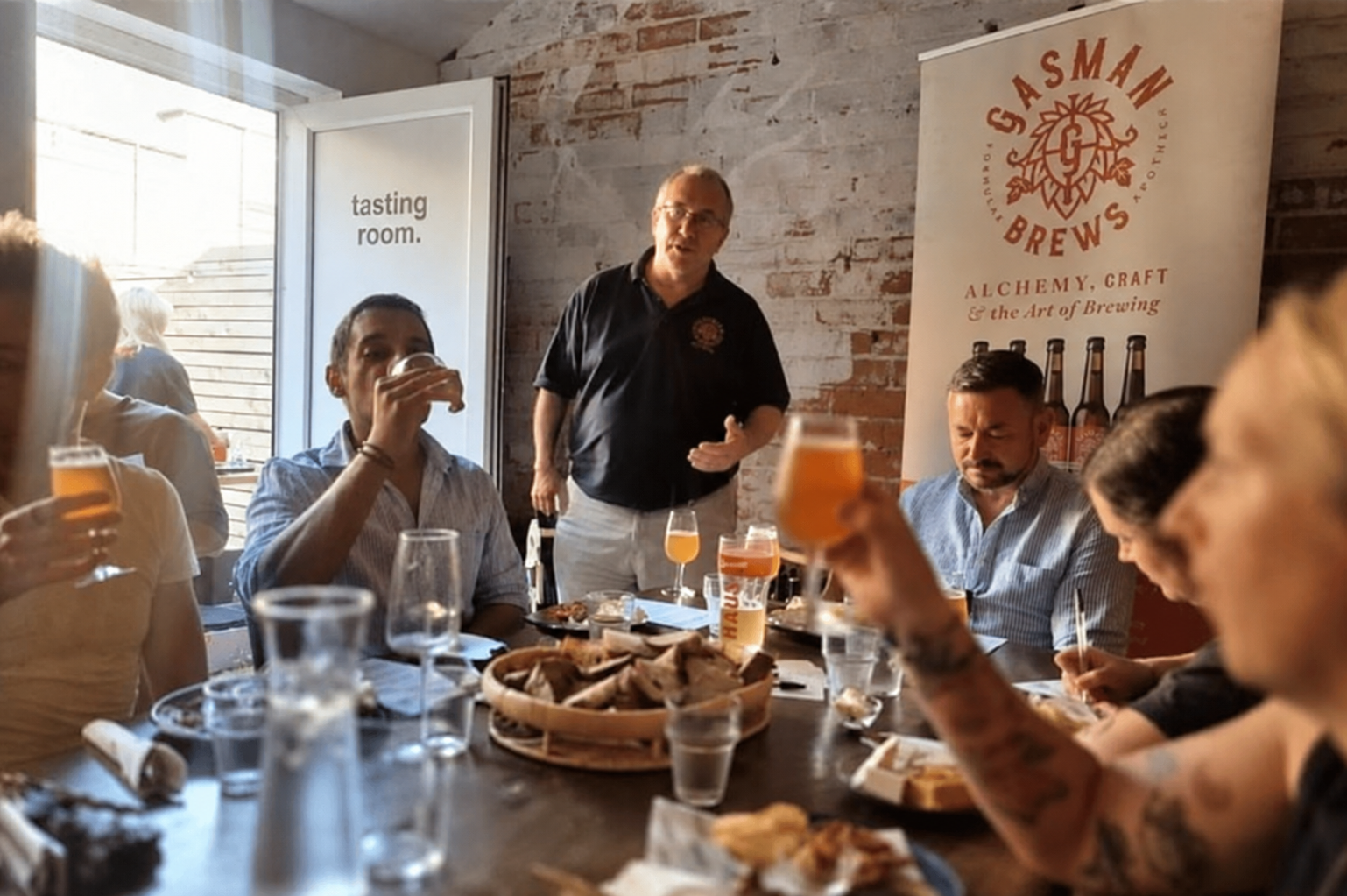 Bryn talking to guests at a tasting table in the Gasman Brews tasting room