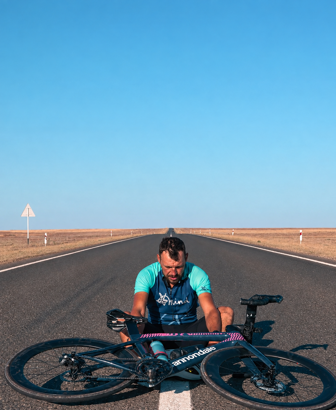 A loaded touring bicycle leaning on a red dirt road in the Australian outback