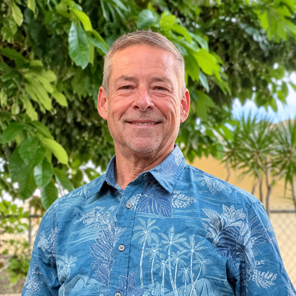 John Clary smiling in a blue tropical shirt