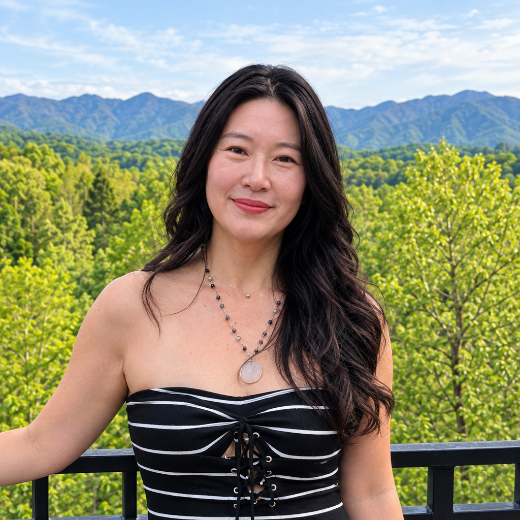 Joomee Kyler smiling with mountain scenery behind her