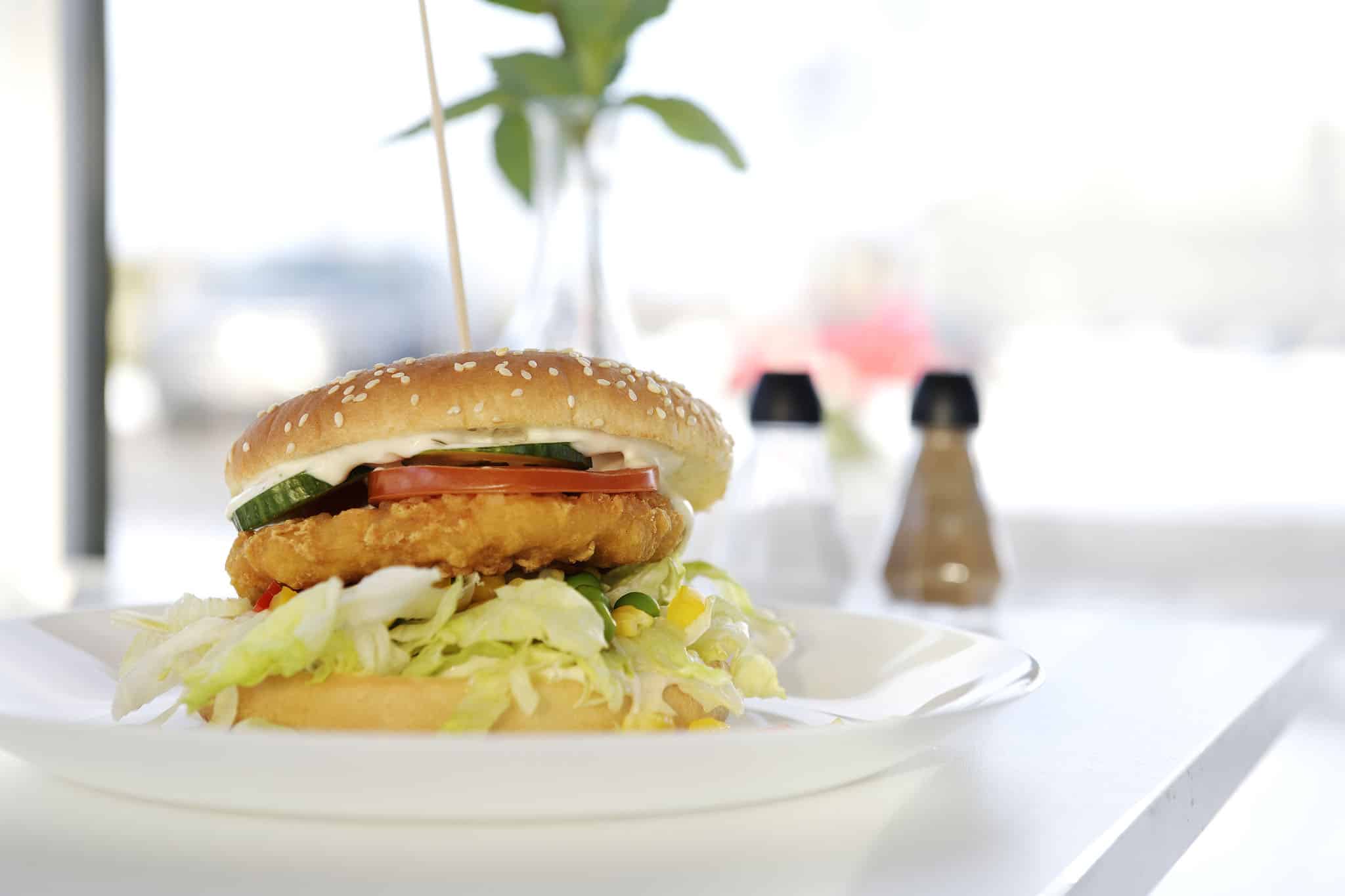 Burger med paneret fyld, salat, tomat og agurk