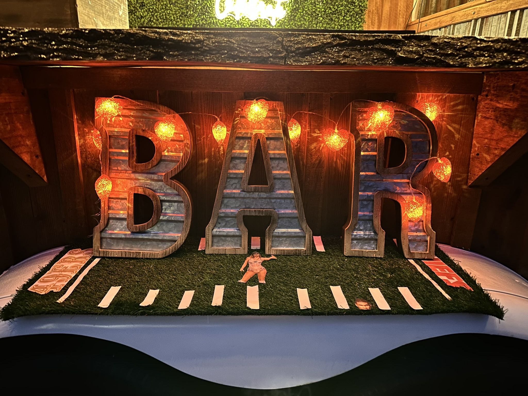 Light-up BAR letters on The Hitching Post mobile bar trailer with football turf backdrop
