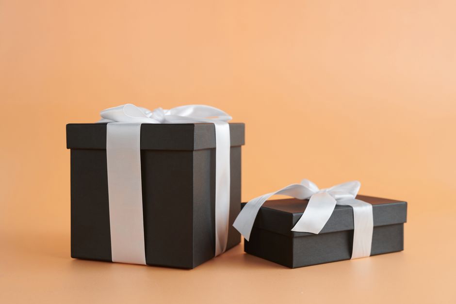 Zwart geschenkdozen met lint in warme lichtval — luxe relatiegeschenken en kerstpakketten