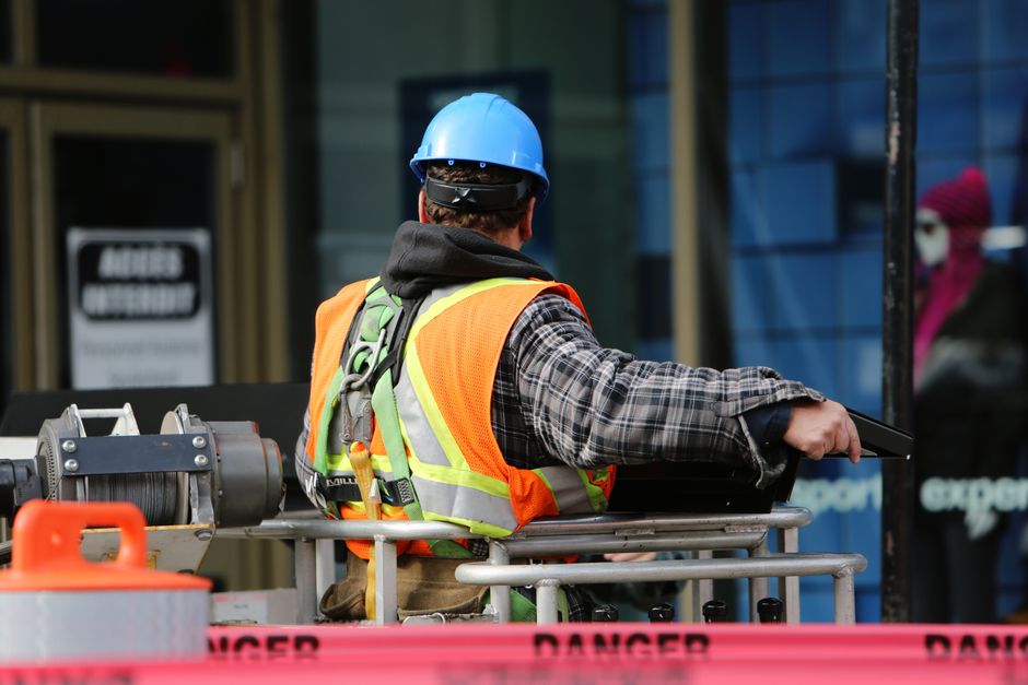 Werker met helm en reflecterend veiligheidsvest op bouwplaats — professionele werkkleding