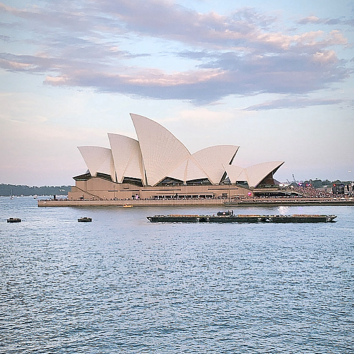 The Sydney Opera House at dusk seen across Sydney Harbour.